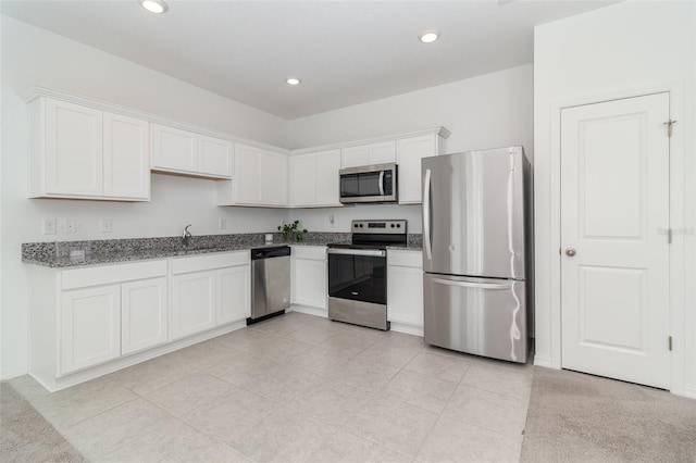 kitchen featuring light stone counters, sink, white cabinetry, and stainless steel appliances