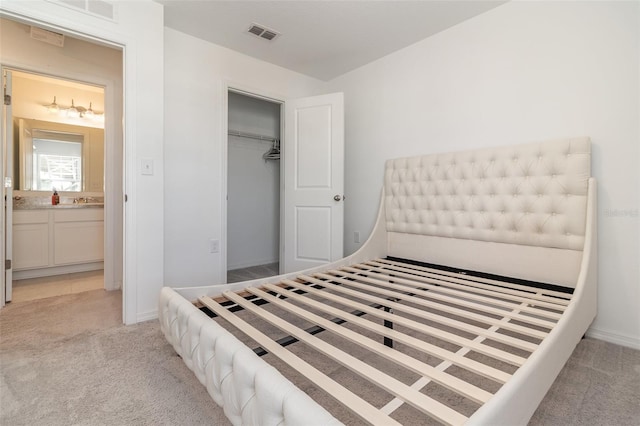 carpeted bedroom with connected bathroom and a closet