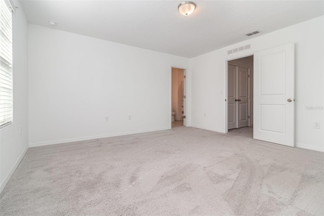 unfurnished room featuring light colored carpet