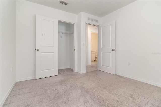 unfurnished bedroom with a closet and light colored carpet