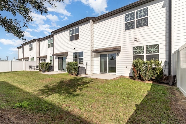 back of property with a yard, central AC, and a patio area