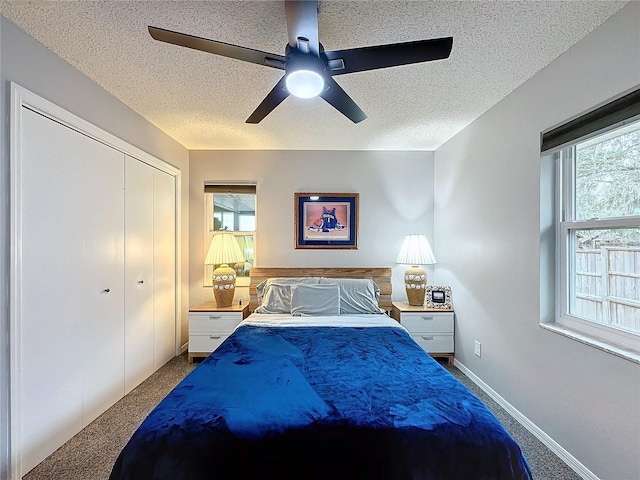 carpeted bedroom with ceiling fan, a textured ceiling, and a closet