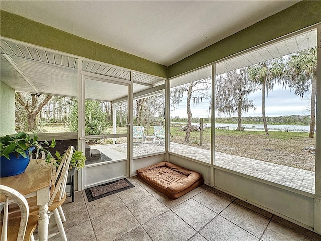 unfurnished sunroom featuring a water view