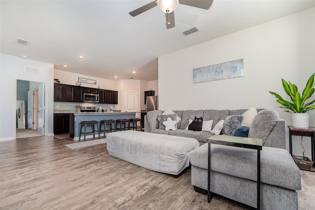 living room featuring ceiling fan and light hardwood / wood-style floors