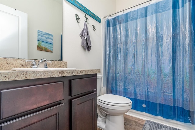 full bathroom with toilet, shower / tub combo with curtain, vanity, and hardwood / wood-style flooring