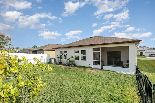 rear view of house with a yard, central AC unit, and a sunroom