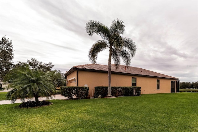 view of home's exterior with a garage and a lawn