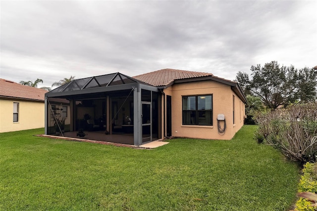 back of house with a lanai and a yard