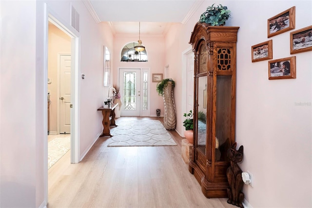 entryway featuring light hardwood / wood-style floors and crown molding