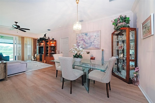 dining space with crown molding, light hardwood / wood-style floors, and ceiling fan with notable chandelier