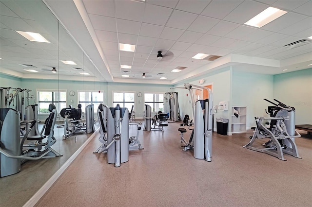 exercise room featuring a paneled ceiling and a wealth of natural light