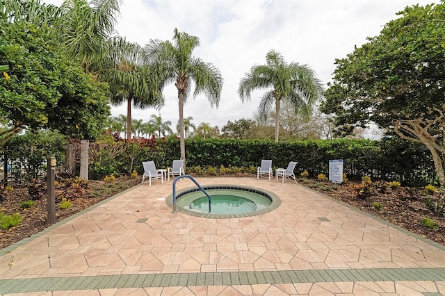 view of swimming pool featuring a patio area and a hot tub