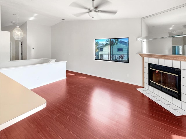 unfurnished living room with ceiling fan, a fireplace, dark hardwood / wood-style floors, and vaulted ceiling