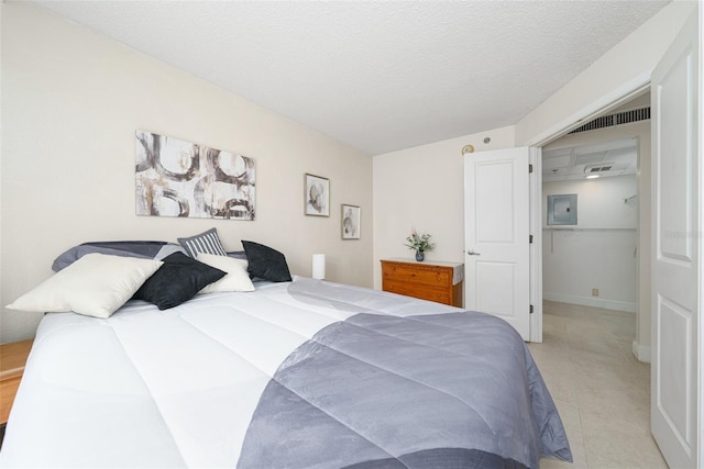 bedroom featuring electric panel and a textured ceiling