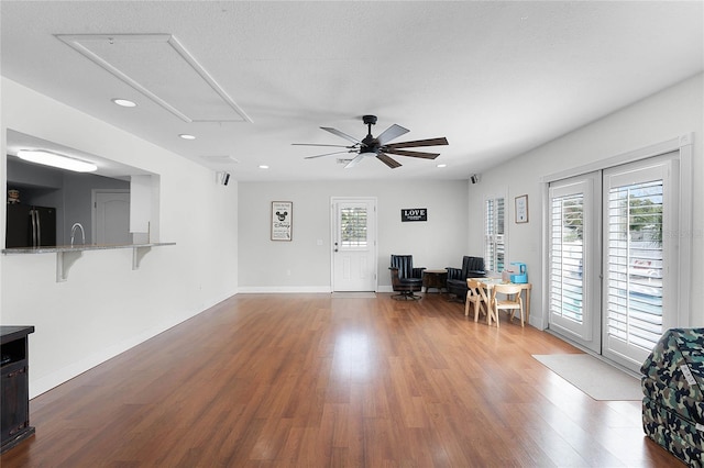 living room with ceiling fan, hardwood / wood-style floors, and a textured ceiling