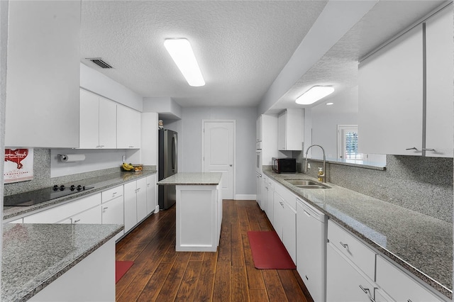 kitchen with light stone counters, sink, and black appliances