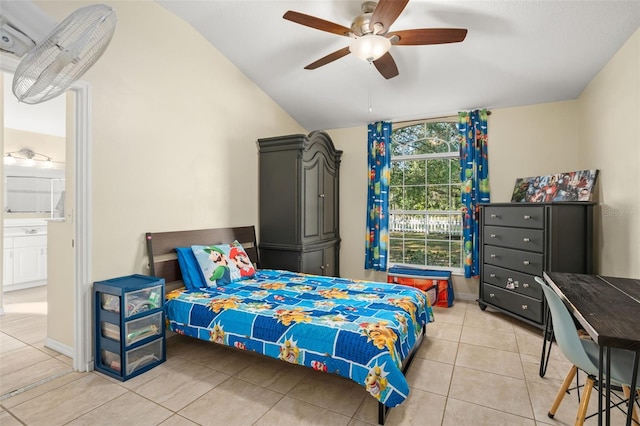 bedroom featuring ceiling fan, light tile patterned floors, ensuite bathroom, and vaulted ceiling