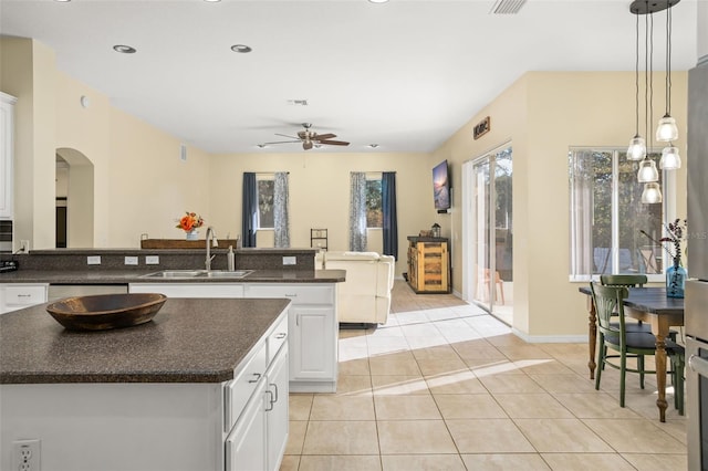 kitchen with sink, pendant lighting, light tile patterned floors, a center island, and white cabinetry