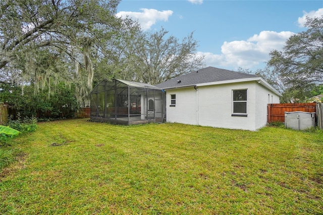 rear view of house featuring a lanai and a yard