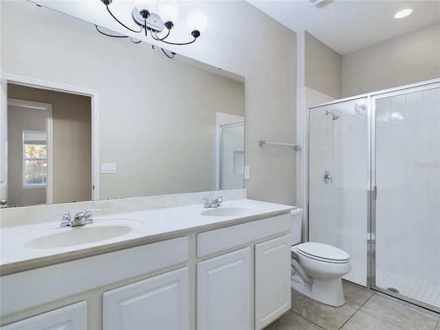 bathroom with tile patterned floors, vanity, a shower with door, and a chandelier