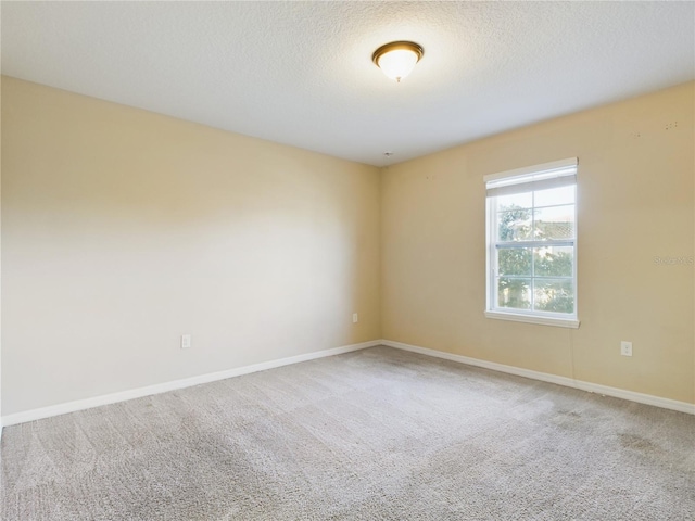 carpeted empty room with a textured ceiling