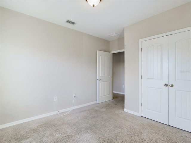 unfurnished bedroom featuring light colored carpet and a closet