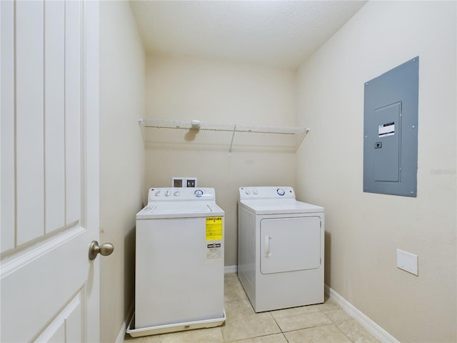 washroom featuring washer and clothes dryer, light tile patterned flooring, and electric panel