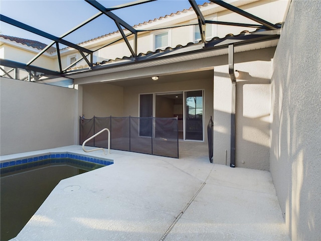 view of swimming pool featuring glass enclosure and a patio area