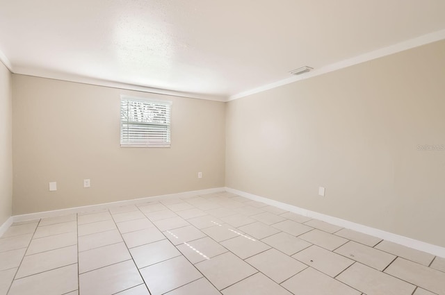 empty room featuring light tile patterned floors and crown molding