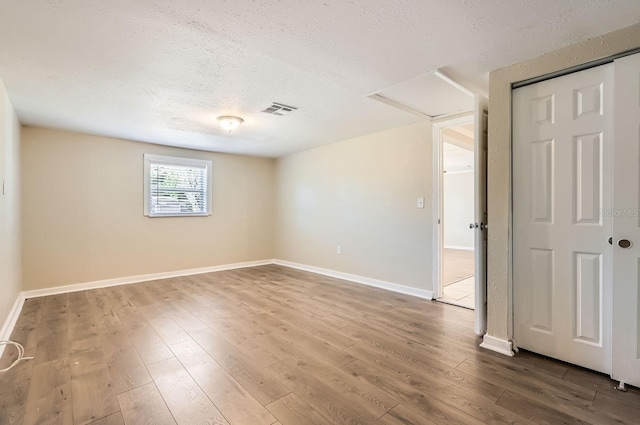 spare room featuring wood-type flooring and a textured ceiling