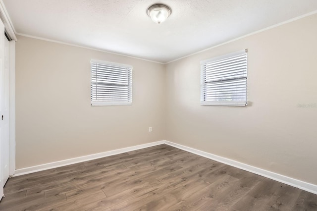 unfurnished room featuring dark hardwood / wood-style floors, a wealth of natural light, and crown molding