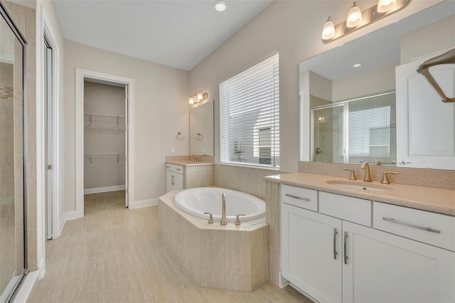 bathroom featuring separate shower and tub and vanity