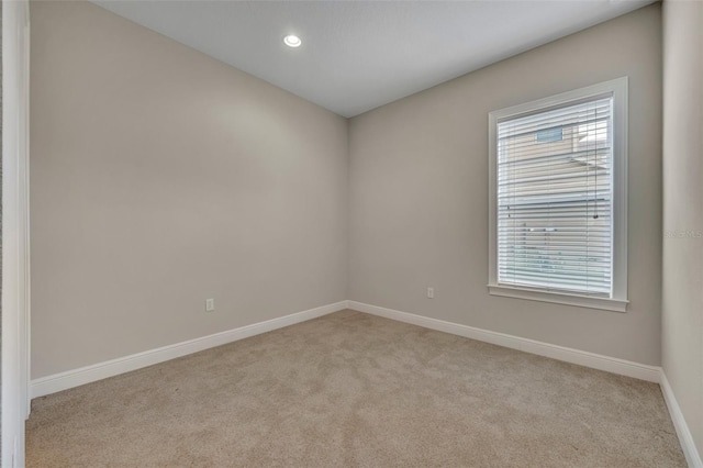 unfurnished room featuring light carpet