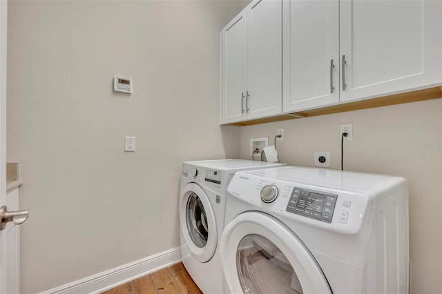 laundry room with washer and dryer, cabinets, and light hardwood / wood-style floors