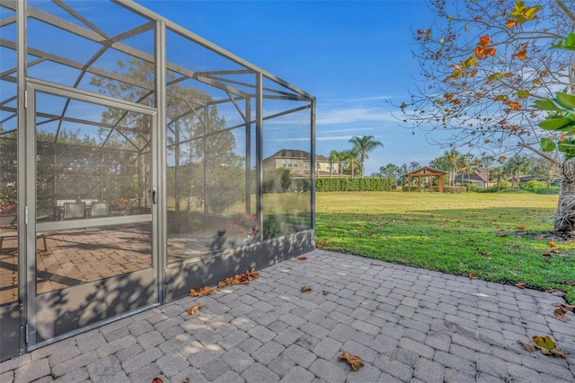 view of patio featuring a gazebo and glass enclosure