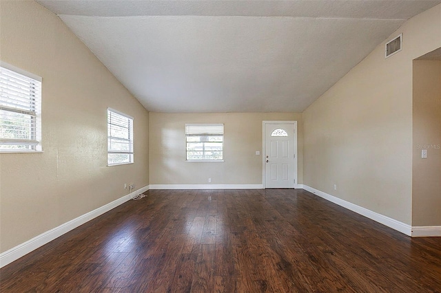 unfurnished room featuring lofted ceiling, a textured ceiling, and dark hardwood / wood-style floors