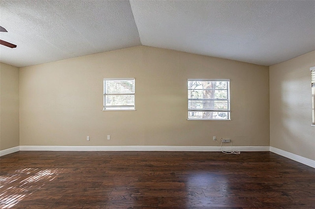 spare room with ceiling fan, dark wood-type flooring, vaulted ceiling, and a textured ceiling