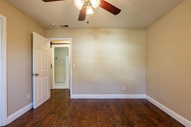 unfurnished room featuring a textured ceiling, ceiling fan, and dark hardwood / wood-style floors