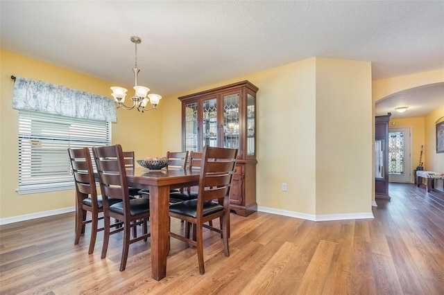 dining room with wood-type flooring and a notable chandelier