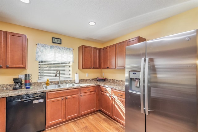 kitchen featuring dishwasher, sink, light stone countertops, light wood-type flooring, and stainless steel fridge with ice dispenser