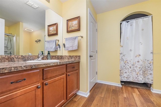 bathroom featuring hardwood / wood-style flooring, vanity, and a shower with shower curtain