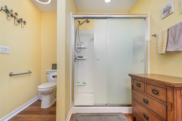 bathroom featuring hardwood / wood-style floors, toilet, and an enclosed shower