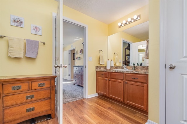 bathroom featuring hardwood / wood-style floors, vanity, and a textured ceiling