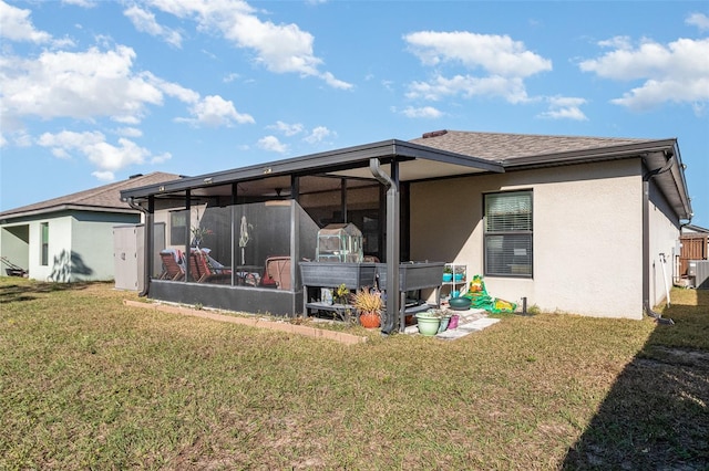 rear view of house with a sunroom, a yard, and central AC unit