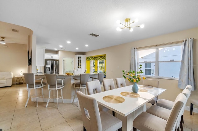 dining area with light tile patterned floors and a chandelier