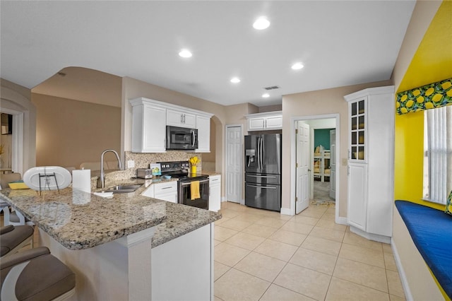 kitchen featuring sink, a breakfast bar area, stainless steel appliances, white cabinets, and kitchen peninsula