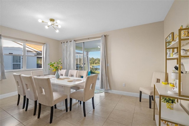 tiled dining space with plenty of natural light and a chandelier