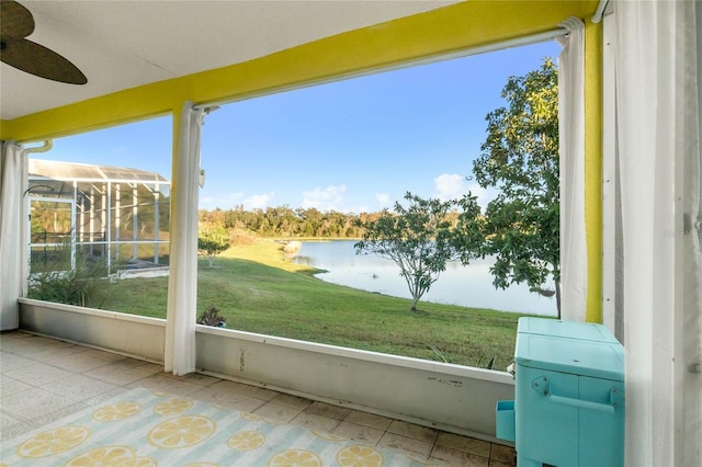 unfurnished sunroom with ceiling fan and a water view