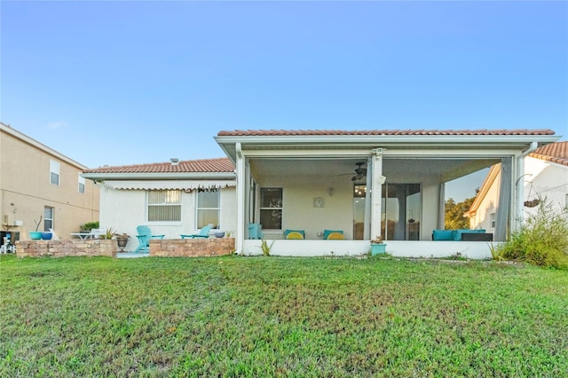 rear view of property featuring a sunroom and a lawn