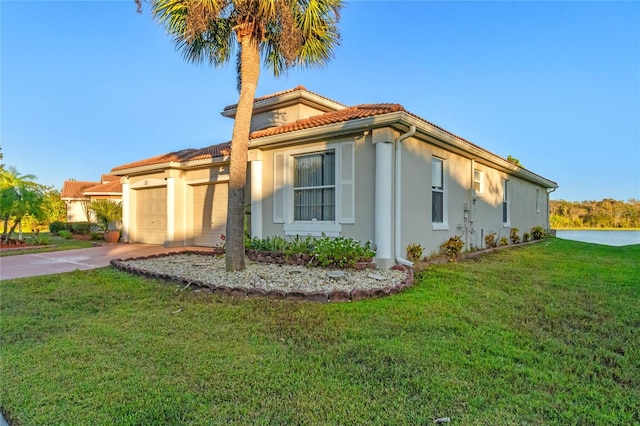 view of property exterior featuring a garage and a lawn